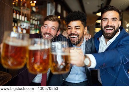 Group Of Friends At The Pub Watcing Football Game And Drinking Beer