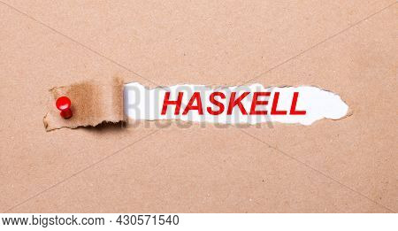 Beneath The Torn Strip Of Kraft Paper Attached With A Red Button Is A White Paper Haskell