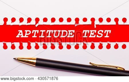 Pen And White Torn Paper Strip On A Bright Red Background With The Text Aptitude Test