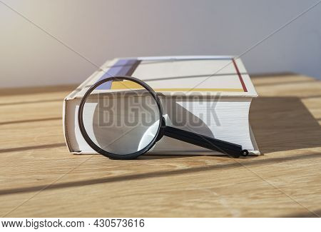Magnifying Lens With Close Thick Book For Study And Reading.