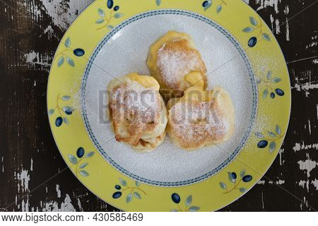 Top View Of Fried Fritters Sifted By Sugar Powder On Plate On Wooden Background