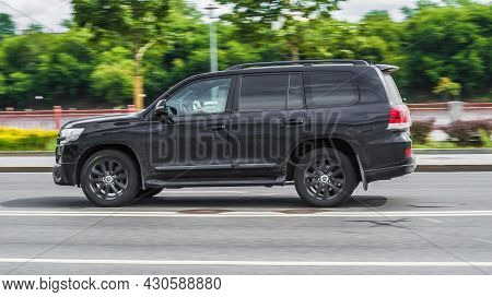 Black Suv Car Toyota Land Cruiser 200 At The City Highway. Auto Moving At High Speed On The Street. 
