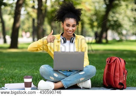 African American Student Girl Using Laptop Gesturing Thumbs-up Sitting Outdoor