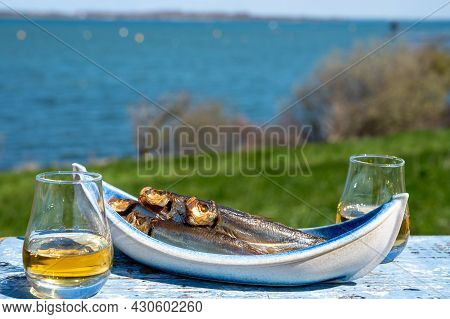Smoked Sprattus Or Sprats Sea Fish Served Outdoor With View On Blue Sea Water