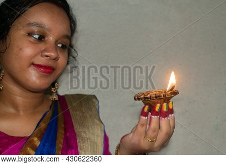 An Indian Woman Holding Diya Or Pradip ( Oil Lamp ) At The Diwali Festival. Selective Focus On Pradi