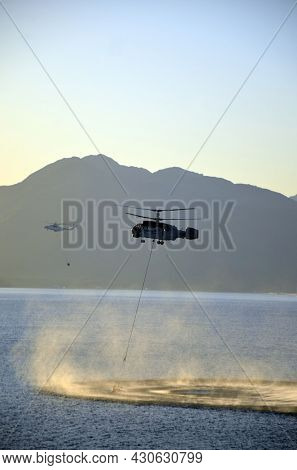 Russian KA-32 helicopter draws water from the sea to extinguish a forest fire. 30 July, 2021. Marmaris,Turkey

