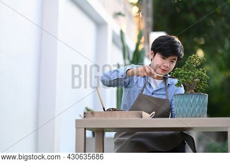 A Young Gardener Man Transplanting Plant As A Hobby Of Home.
