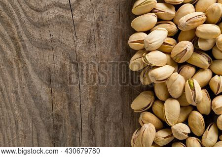 Border Of Salted, Roasted Green Pistachio Nuts Snack On Wood Background, Healthy Food Snack, Copy Sp
