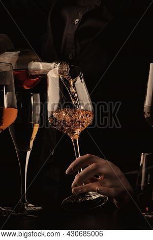 Sommelier Pouring Rose Wine Into Glass At Wine Tasting In Winery, Bar Or Restaurant. Black Toned Ima