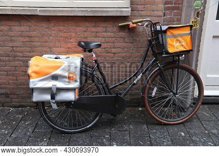 Amsterdam, Netherlands - December 6, 2017: Mailman Bicycle Parked In Amsterdam. Mail Delivery By Pos