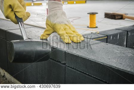 Worker Levelling Patio Concrete Floor Bricks Close Up Industrial Photo. Bricks Paving Theme.