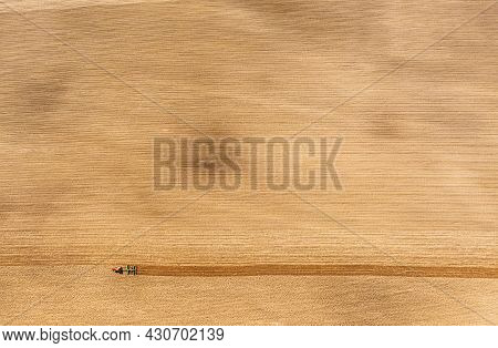 Tractor Plowing Field In Spring. Beginning Of Agricultural Season. Cultivator Pulled By A Tractor In