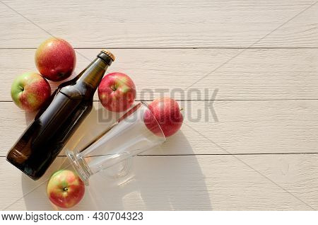 Bottle Of Cider And Glass Near Apples On Wooden Background, Top View, Copy Space