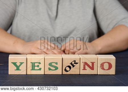 Wooden Cubes With The Inscription Yes And No On A Nlue Background. The Concept Of Analyzing And Choo