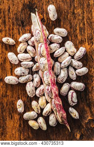 Cranberry beans. Borlotti beans. Beans pods on wooden table. Top view.