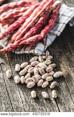 Cranberry beans. Borlotti beans. Beans pods on wooden table.
