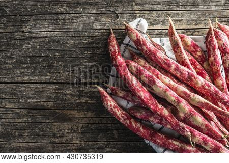 Cranberry beans. Borlotti beans. Beans pods on wooden table. Top view.
