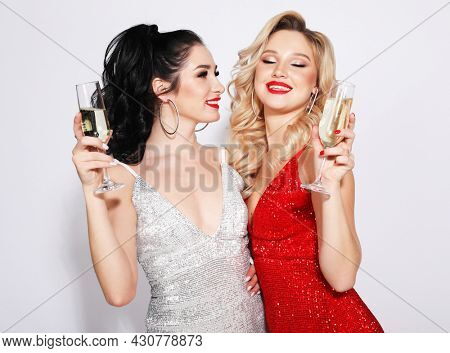 Couple of Two Young Rich Women - blonde and brunette Laughing with Crystal of Champagne. Luxury. Party time.