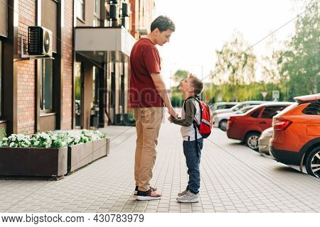 Happy Father And Kid Son Going To Classes. Parent Take Child Boy To School In First Grade. Pupil Of 
