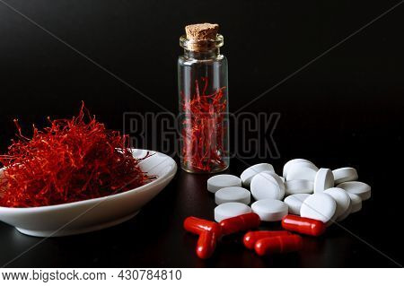 Dry Saffron Stamens On A Black Background. Stigmas In Vessels. Saffron-based Tablets.