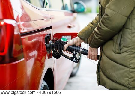 Close-up Of Hands Of Woman At Self-service Gas Station, Hold Fuel Nozzle And Refuel The Car With Pet