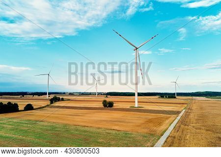 Windmill Among Agricultural Fields. Wind Turbine Generator At Summer Day. Wind Energy Concept, Suist