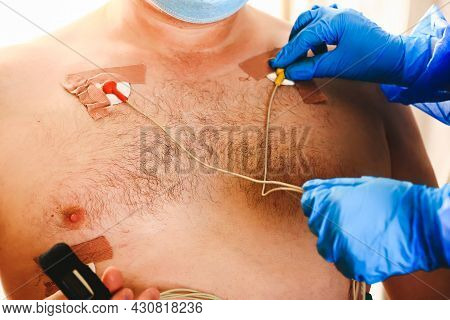 Doctor Attaches A Holter To The Mans Chest. Daily Monitoring Of The Heart. Cardiology.