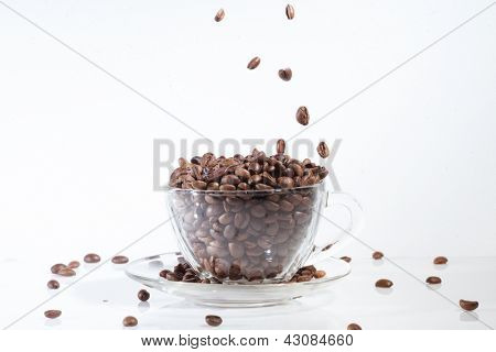 Taza de café en con frijoles, en fondo blanco con granos de caída