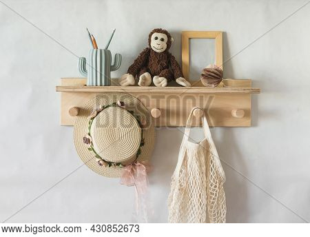 Wooden Shelf In The Children's Room On The Wall With Toys, A Children's Straw Hat, A Bag. Interior C