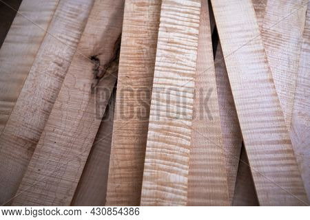 Curly maple or flame maple, tiger maple a sought after and prized wood for its beautiful figured grain. Wood working lumber on work bench.