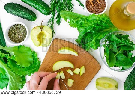 Woman Cooking Salad Of Fresh Green Vegetables And Herbs. Raw Food Concept. Vegan Menu. Cooking Healt