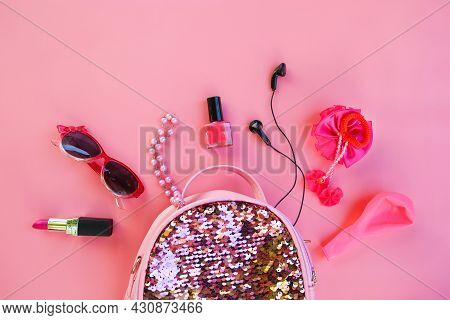 Children's Backpack With Cosmetics And Women's Accessories On Pink Background. Top View, Flat Lay.