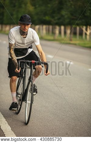 Young Male Sportsman Riding A Bike On Open Air. Concept Of Youth, Strenghth, Action, Motion, Healthy