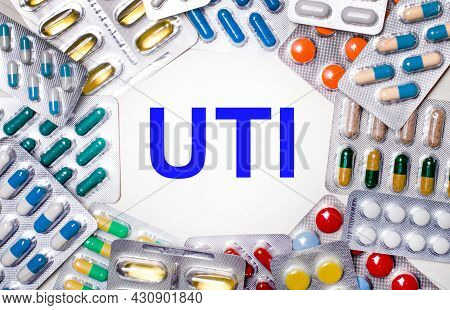 The Word Uti Is Written On A Light Background Surrounded By Multi-colored Packages With Pills. Medic