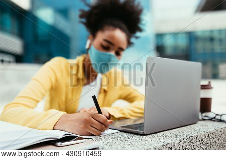 African Student Girl Taking Notes Learning At Laptop Outdoor
