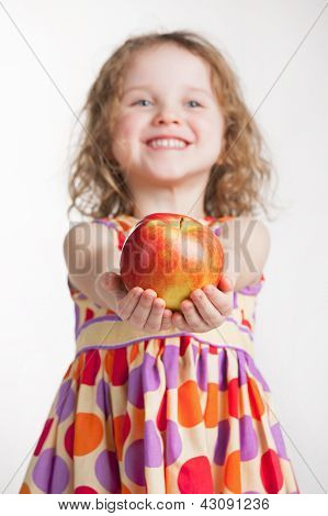 Liten flicka håller ett äpple