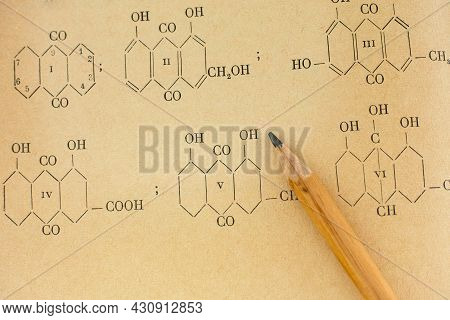 A Pencil Lies On A Page Of Old Chemistry Book With Chemical Formulas.