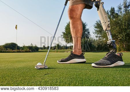 Professional Golfer With Prosthetic Leg Hitting With Putter On Golf Ball During Golfing. Concept Of 