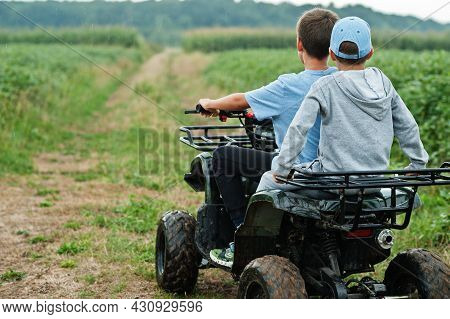 Two Brothers Driving Four-wheller Atv Quad Bike. Happy Children Moments.