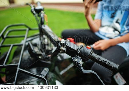 Boy In Four-wheller Atv Quad Bike With Mobile Phone.