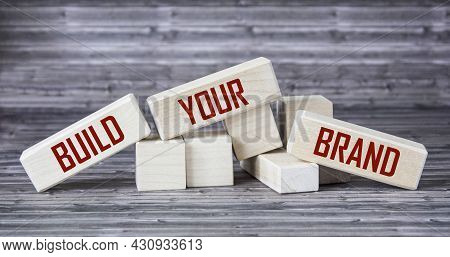 Conceptual Image, Word Build Your Brand On Wooden Blocks And Wooden Table.