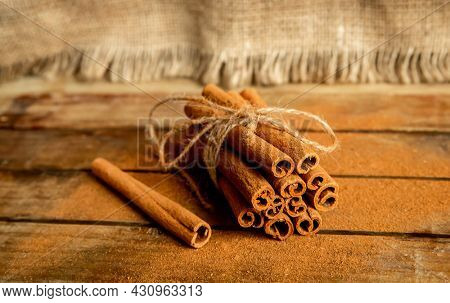 CINNAMON STICKS ON WOODEN BACKGROUND