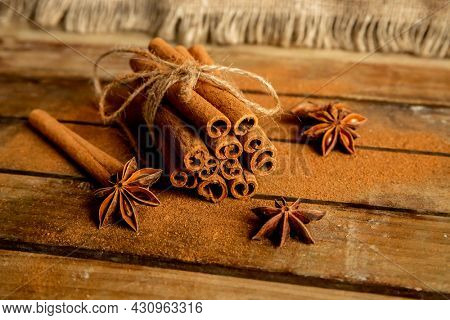 CINNAMON STICKS ON WOODEN BACKGROUND