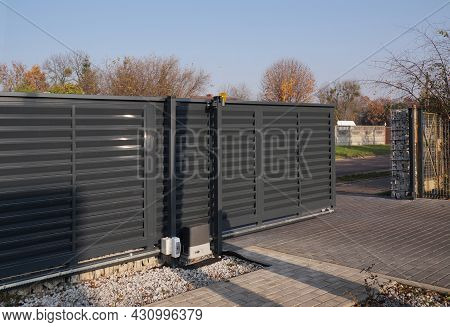 Automatic Entrance Gate Used In Combination With A Wall Made Of Gabion.