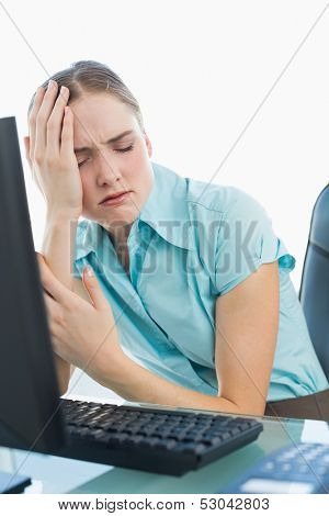 Classy wincing businesswoman having a headache in bright office