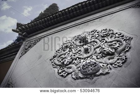 Ornate low relief sculpture of dragon on wall.