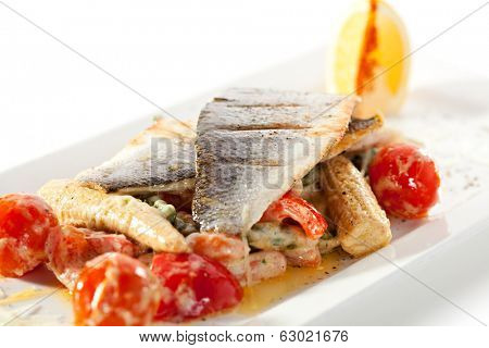 Fillet of Seabass with Tomato and Mussels Sauce. Garnished with Vegetables