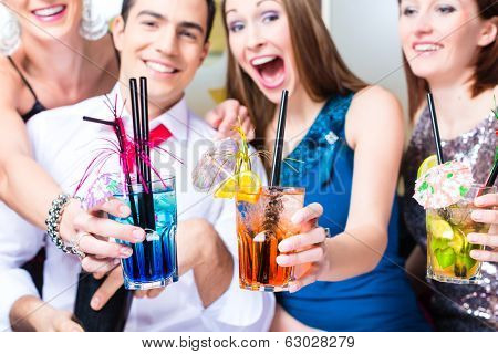 Friends drinking with barkeeper cocktails in fancy night club 
