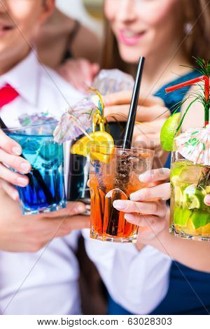 Friends drinking with barkeeper cocktails in fancy night club