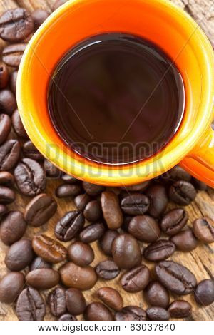 Cup Of Black Coffee And Coffee Beans On Wooden Background.